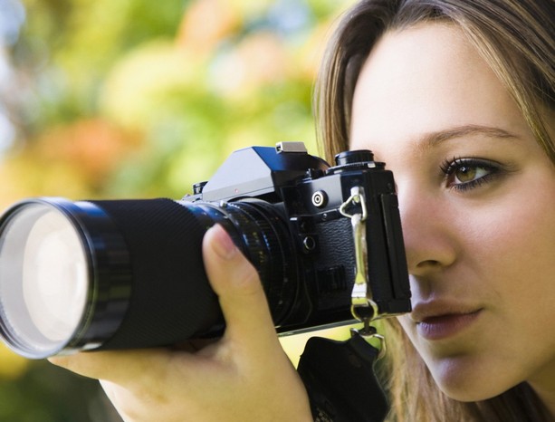 Teenage girl taking a picture with camera